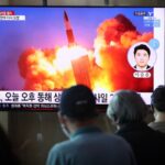 people watching a TV at the Seoul Railway Station showing a file image of a North Korean missile launch, on September 15, 2021 in Seoul, South Korea