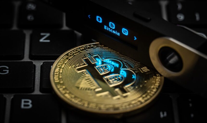 The word Bitcoin can be seen on the display of a Ledger Nano S hardware wallet next to a symbolic "Bitcoin coin". Photo: Silas Stein/dpa (Photo by Silas Stein/picture alliance via Getty Images)