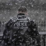 A uniformed Secret Service officer stands watch in the snow outside the White House in Washington, DC, on January 19, 2025.