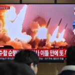 People stand near a television showing a news broadcast with file footage of a North Korean missile test, at a railway station in Seoul on March 14, 2023. - North Korea fired two short-range ballistic missiles on March 14, 2023, Seoul said, Pyongyang's second launch in three days and the first since South Korea and the United States began their largest joint military drills in five years.