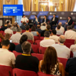 Un grupo de expectadores frente a un panel en un foro de criptomonedas en un auditorio de España.