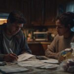 Couple reviewing bills at a kitchen table during rising costs, illustrating stagflation pressures and why Bitcoin holders need to understand its impact